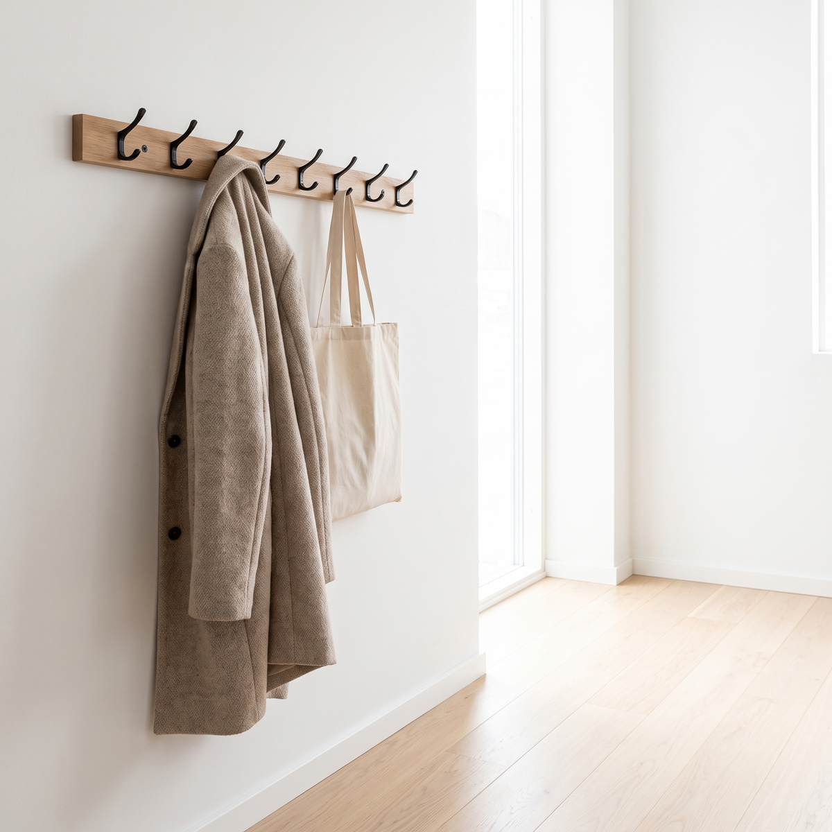 Wooden hook rail with a coat and tote bag