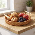 Round rattan tray with bread and fruit on a kitchen counter